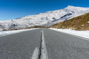 Empty road towards the snow-covered Sierra Nevada mountains. Granada, Spain photo