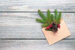 Christmas tree twigs in paper envelope on wooden background, eco sustainable decorations trend photo