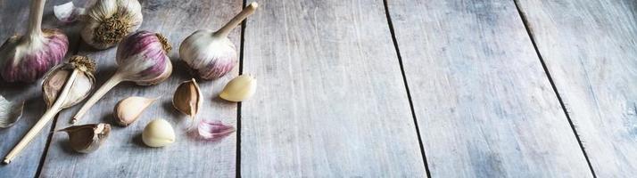 Garlic bulbs and cloves on wooden table, food background, copy space photo