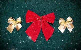red and golden bows for Christmas tree decoration on dark green background. photo