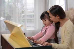 Mother and Child Playing Piano Together at Home photo