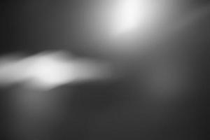 Defocus blurred abstract dark gray gradient spotlight floor texture background. Dark gray with shining background. photo