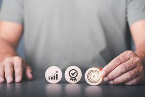 success and business target concept, planning analysis business competition, market growth opportunities,a businessman chooses a wooden block with icons representing clear business targeting photo