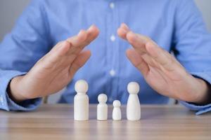 People protect family on wooden table health care and life insurance concept photo