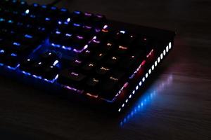 RGB gaming keyboard on wooden table, e-sports concept photo