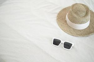 Empty white glasses and brown straw hats on the bed.Holiday concepts photo