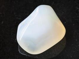 polished white Agate gemstone on dark background photo
