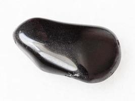 tumbled black obsidian gemstone on white photo