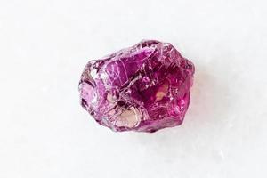 rough Rhodolite pyrope garnet crystal on white photo
