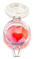 glass heart on pile of paper hearts in open jar photo
