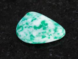 polished amazonite gem stone on dark photo