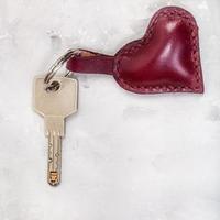 llave con abalorio de cuero en forma de corazón sobre hormigón foto