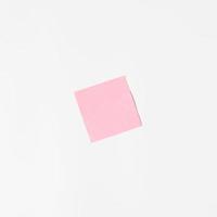 Pink sticker on a white wall, mock up. Blank sticky sheet, minimalism photo