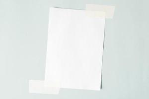 una hoja de papel pegada torcidamente en la pared. maqueta de hoja blanca, espacio de copia. foto