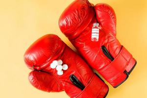 ampolla y pastillas en guantes de boxeo, vista superior. concepto de lucha sucia. dopaje para el atleta. foto