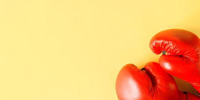 Red boxing gloves on a yellow background, top view. Sports banner, copy space photo