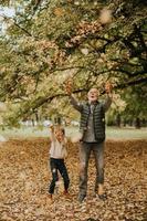 abuelo pasando tiempo con su nieta en el parque el día de otoño foto