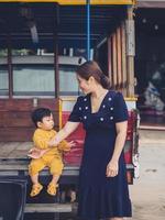 Asian mother and son of Thai nationality and old car at De mala Cafe, Thung Saliam, Sukhothai, Thailand. photo