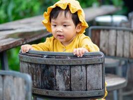 Asian baby of Thai nationality on vintage chair at De mala Cafe, Thung Saliam, Sukhothai, Thailand. photo