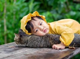 Asian baby of Thai nationality and cat at De mala Cafe, Thung Saliam, Sukhothai, Thailand. photo