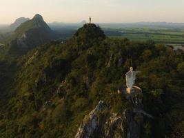 una vista aérea de cristo redentor y buda en la montaña se destaca prominentemente en hup pha sawan en ratchaburi cerca de bangkok, tailandia foto