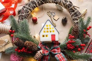 Key to the house with a keychain on a cozy home with a Christmas decor layout. A gift for New Year, Christmas. Building, design, project, moving to new house, mortgage, rent and purchase real estate