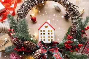 Cozy house in Christmas decor layout, warm knitted scarf, hat, winterization. Winter, snow - home insulation, protection from cold weather, room heating system. Festive mood, Christmas, New Year