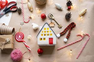 llave de la casa con un llavero en una casa acogedora con un diseño de decoración navideña. un regalo para año nuevo, navidad. construcción, diseño, proyecto, mudanza a casa nueva, hipoteca, alquiler y compra de bienes raíces