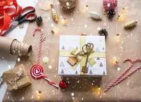 Key to house with keychain on cozy home in gift box with Christmas decor packaging. Pack present for New Year, Christmas. Building, project, moving to new house, mortgage, rent, purchase real estate photo