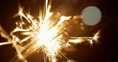 primer plano de los fuegos artificiales que queman bengalas en la noche de fiesta de año nuevo, hermoso brillo con destellos en la escena nocturna video