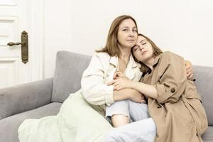 Parents and teens.Mom and teenage daughter are sitting on the couch. Conflict, difficult age. Family. photo