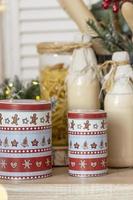 Table in the kitchen with bottles of milk, cups and Christmas decorations photo