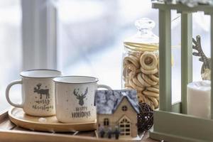 Morning Christmas coffee with marshmallows and Christmas decorations on a tray table by the window on the windowsill photo