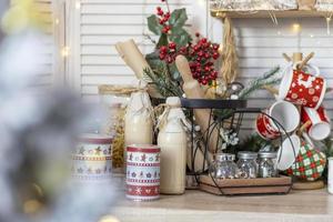 mesa en la cocina con botellas de leche, tazas y adornos navideños foto