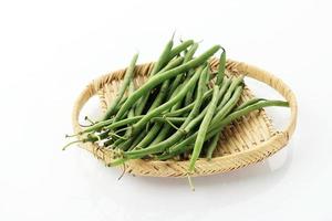 Pile of Raw Green Baby Fine Beans on a Rattan Tray Plate photo