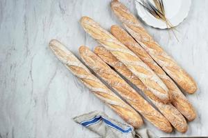 baguettes suaves francesas recién horneadas sobre una mesa de mármol blanco. foto