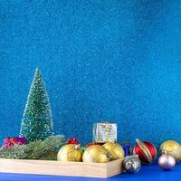 Christmas background, gold ornament ball and gift boxes on glitter blue background with copy space. photo