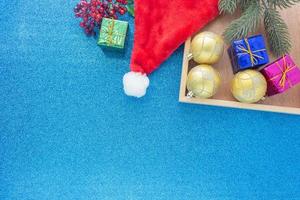 Christmas background, gold ornament ball and gift boxes on glitter blue background with copy space in top view photo
