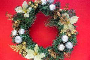Christmas wreath on red background with copy space in top view