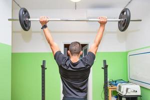 un chico con levantamiento de pesas en el gimnasio foto