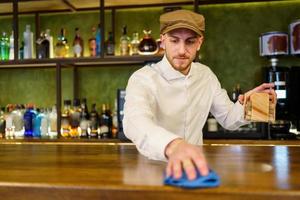 Bartender cleaning counter in a nice pub photo