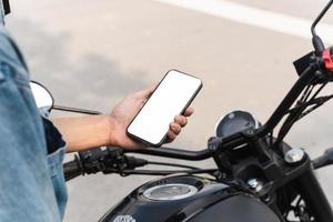 image of asian man, sitting on moto using mobile phone photo