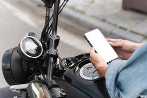 image of asian man, sitting on moto using mobile phone photo