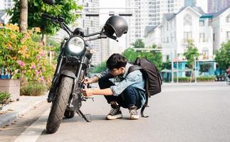 Young Asian man repairing motorbike photo