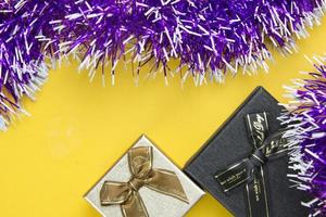 Two gift boxes and purple ribbons decorative festive object place on yellow background, nice new year decorective object concepts design.