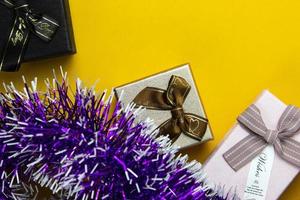 diseño de año nuevo y navidad. cajas de regalo realistas de color rosa, negro y dorado. objeto festivo decorativo de caja de regalo. banner de vacaciones sobre fondo amarillo de navidad.