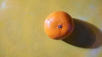 ángulo superior, fruta naranja sobre un fondo amarillo 02 foto