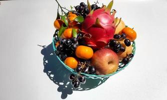 Tropical fruit in green basket on white background 01 photo