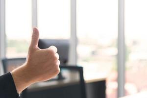 Successful business concept. Businessman show thumbs up to employees in the modern meeting room photo
