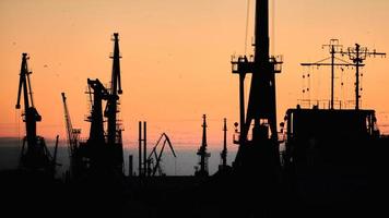 Silhouettes of ships and container cranes in sea port photo